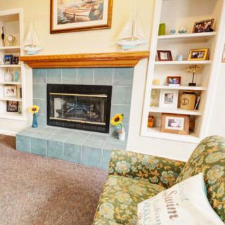 A cozy living room with a fireplace and decorative shelves.
