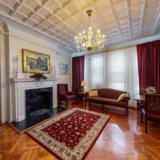 A classic living room with a chandelier, fireplace, and elegant decor.