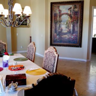 A beautifully arranged dining room featuring a large painting and an elegant chandelier.