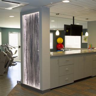 A modern, open-concept kitchen area with contemporary lighting and adjacent exercise equipment.