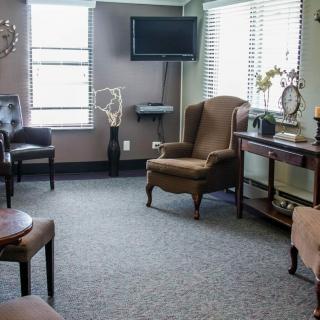 A cozy waiting room with chairs, a television, and decorative elements.