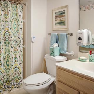 A well-organized bathroom with a patterned shower curtain and neatly arranged toiletries.