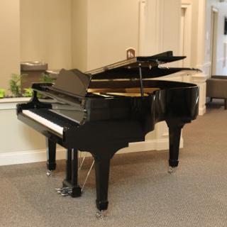 A beautiful black grand piano sits elegantly in the spacious interior.