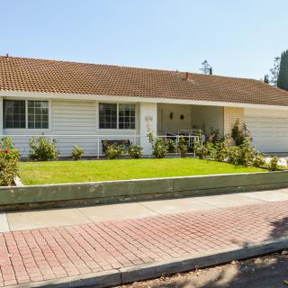 A suburban single-story house with a well-maintained front yard.