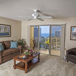 A cozy living room with a balcony offering an ocean view.
