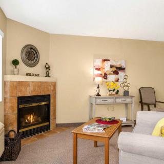 A cozy living room with a fireplace, sofa, and decor items, creating a warm and inviting atmosphere.