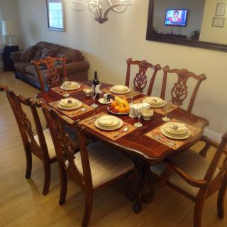 A dining table elegantly set for a meal in a cozy living room setting.