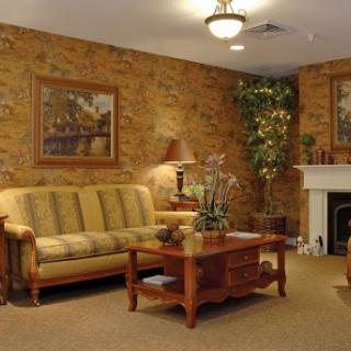 A cozy living room featuring a comfortable sofa, a wooden coffee table, and decorative artwork on the walls.