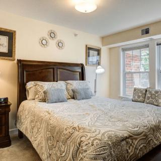 A cozy bedroom with a large bed, wooden headboard, and decorative pillows by the window.