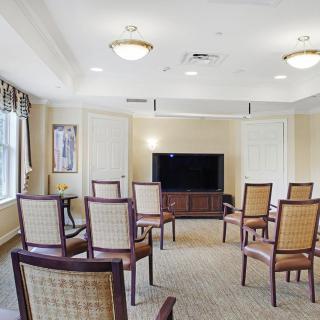A small meeting room with a television and arranged chairs.