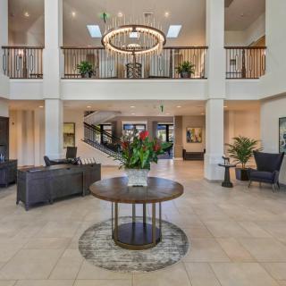 A modern lobby with a central table, chandelier, and elegant furnishings.
