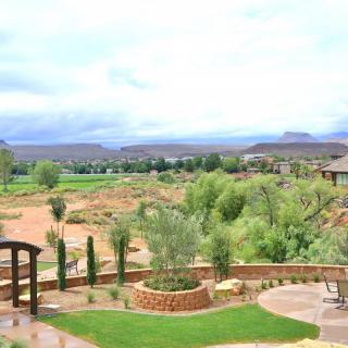 A scenic view of a landscaped garden overlooking a rural landscape with distant hills.