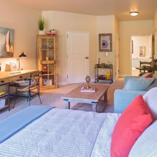 A modern and cozy living room with a workspace area, featuring comfortable seating and stylish decor.