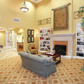 A cozy living room featuring a fireplace, bookshelves, and a comfortable couch.