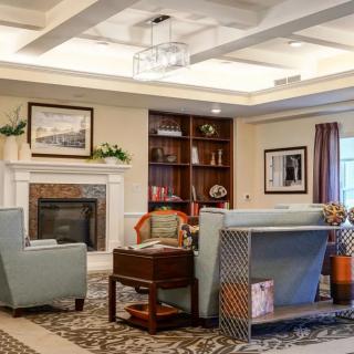 A cozy living room with elegant furniture, a fireplace, and bookshelves.