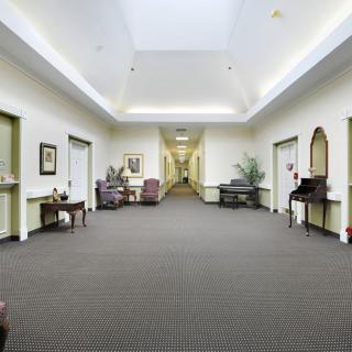 A well-lit hallway with various pieces of furniture and decorations.