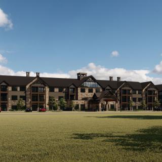 A large residential building with a spacious grass area in front, under a clear blue sky.