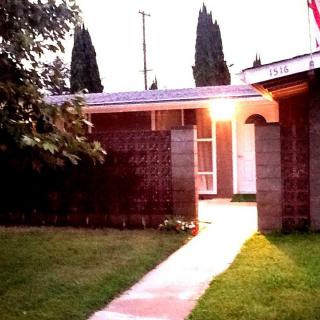 A cozy house with a lit entrance pathway during the evening.