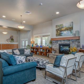 A beautifully designed living room featuring a cozy seating arrangement, a fireplace, and abundant natural light.