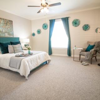 A cozy bedroom with modern decor featuring teal accents and a comfortable bed.