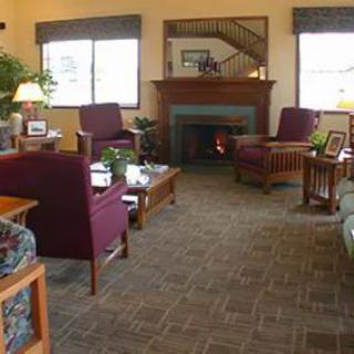A cozy living room with a fireplace, comfortable seating, and warm decor.