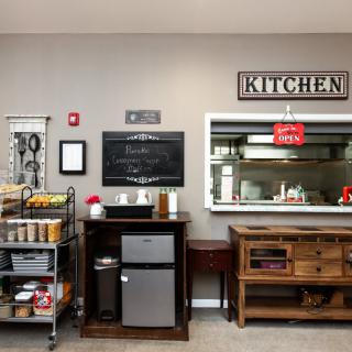 A well-organized kitchen space featuring storage shelves, appliances, and decorative elements.