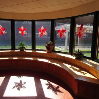 Sunlit room with red pinwheel decorations on the windows.