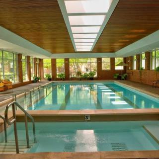 A serene indoor swimming pool with natural lighting and wooden interior.