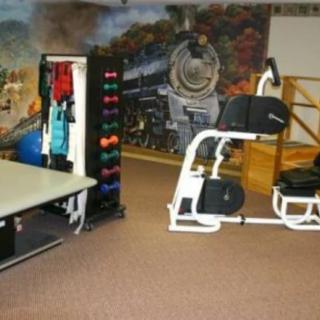 A fitness room equipped with gym machines and colorful weights.