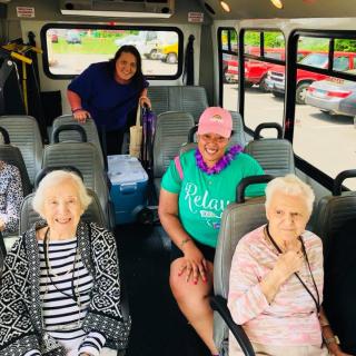 A cheerful group of elderly individuals sits together on a bus.
