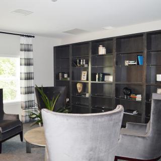 A modern living room with a large bookshelf and comfortable seating.