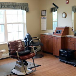 A cozy barbershop interior featuring a classic barber chair and large mirrors.