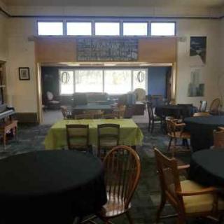 An indoor space set up with tables and chairs, possibly for meetings or events.