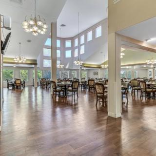 A spacious dining area with elegant lighting and wooden flooring.