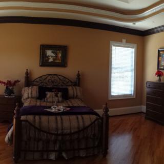 A cozy bedroom with a metal-framed bed, wooden dresser, and decorative accents.