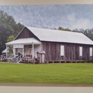 A charming wooden building surrounded by lush grass, showcasing simple rural architecture.