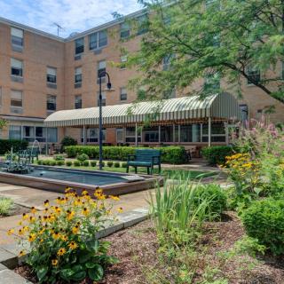 A courtyard with a garden and benches in front of a residential building.