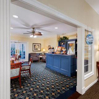 A welcoming reception area with a blue desk, comfortable seating, and decorative elements.