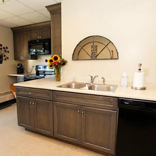 A modern kitchen layout featuring dark cabinets, a double sink, and decorative elements including flowers.
