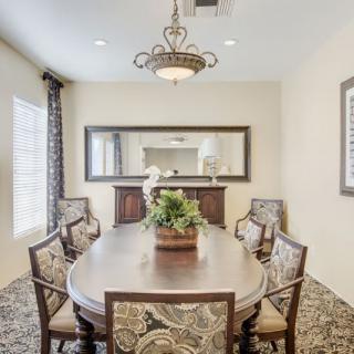 Elegant dining room with ornate chairs and a large mirror.