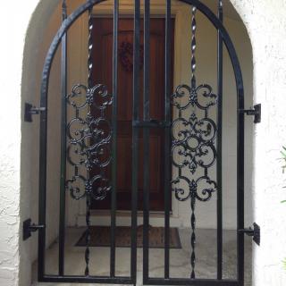 A decorative iron gate with intricate designs at an entrance.