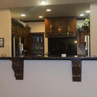 A modern kitchen with dark cabinets and a granite countertop.