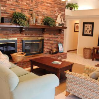 Cozy living room with a brick fireplace and comfortable seating.