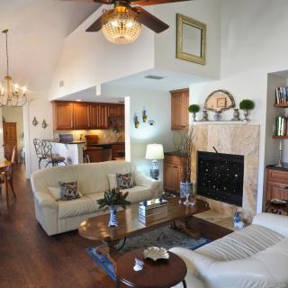 A spacious living room with a cozy fireplace and comfortable seating, seamlessly connected to an open kitchen and dining area.