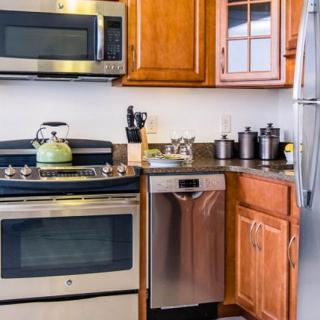 A modern kitchen with stainless steel appliances and wooden cabinets.