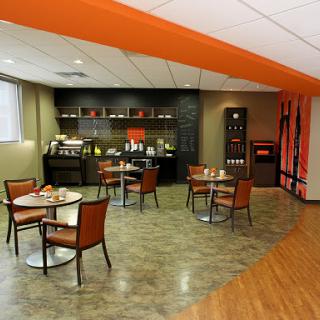 A modern waiting area featuring stylish chairs and a coffee station.