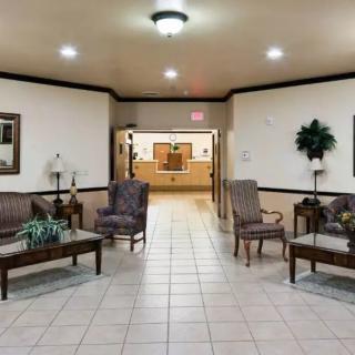 A well-lit lobby with comfortable seating and a reception desk in the background.