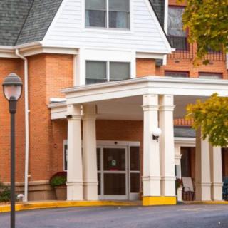 The main entrance of a residential building with brick exterior and white columns.
