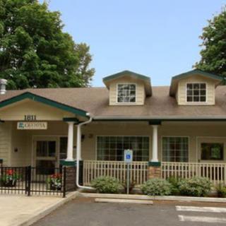 A charming residential building featuring a welcoming porch and well-kept landscaping.
