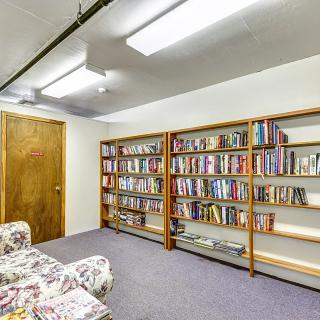 A cozy library room with bookshelves and comfortable seating.